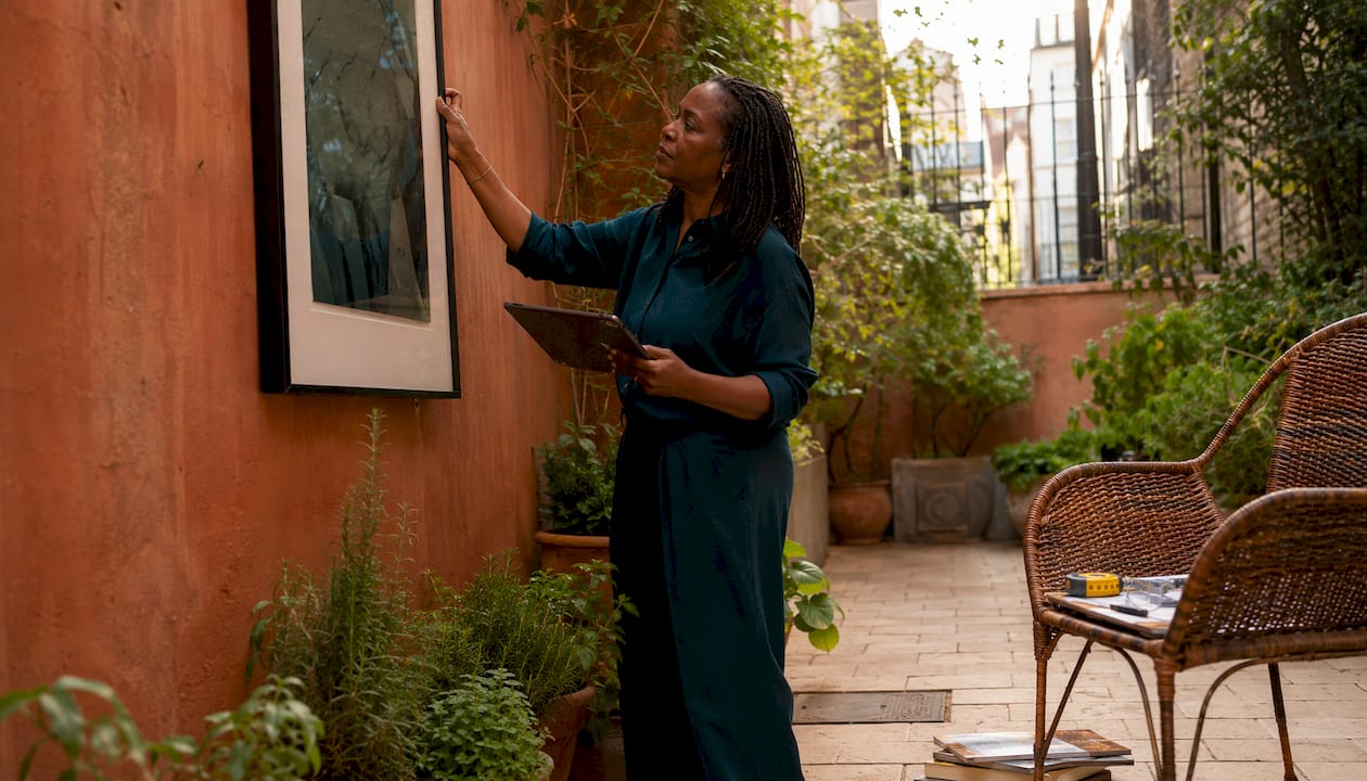 Woman arranging framed artwork in studio