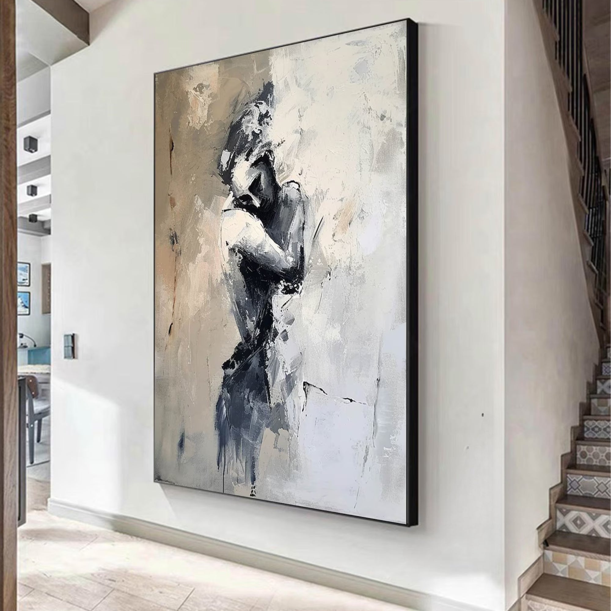 Large contemporary canvas featuring a grayscale impression of two lovers hugging, hung in a minimalist, art-filled interior.