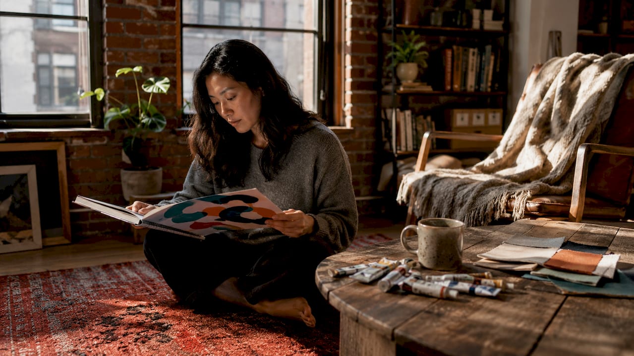 Woman reviewing art theme sketches in living room
