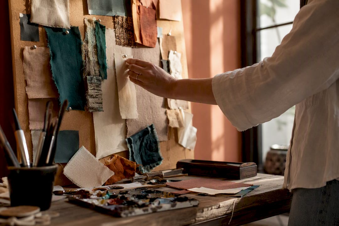 Hand pinning swatch on textured corkboard