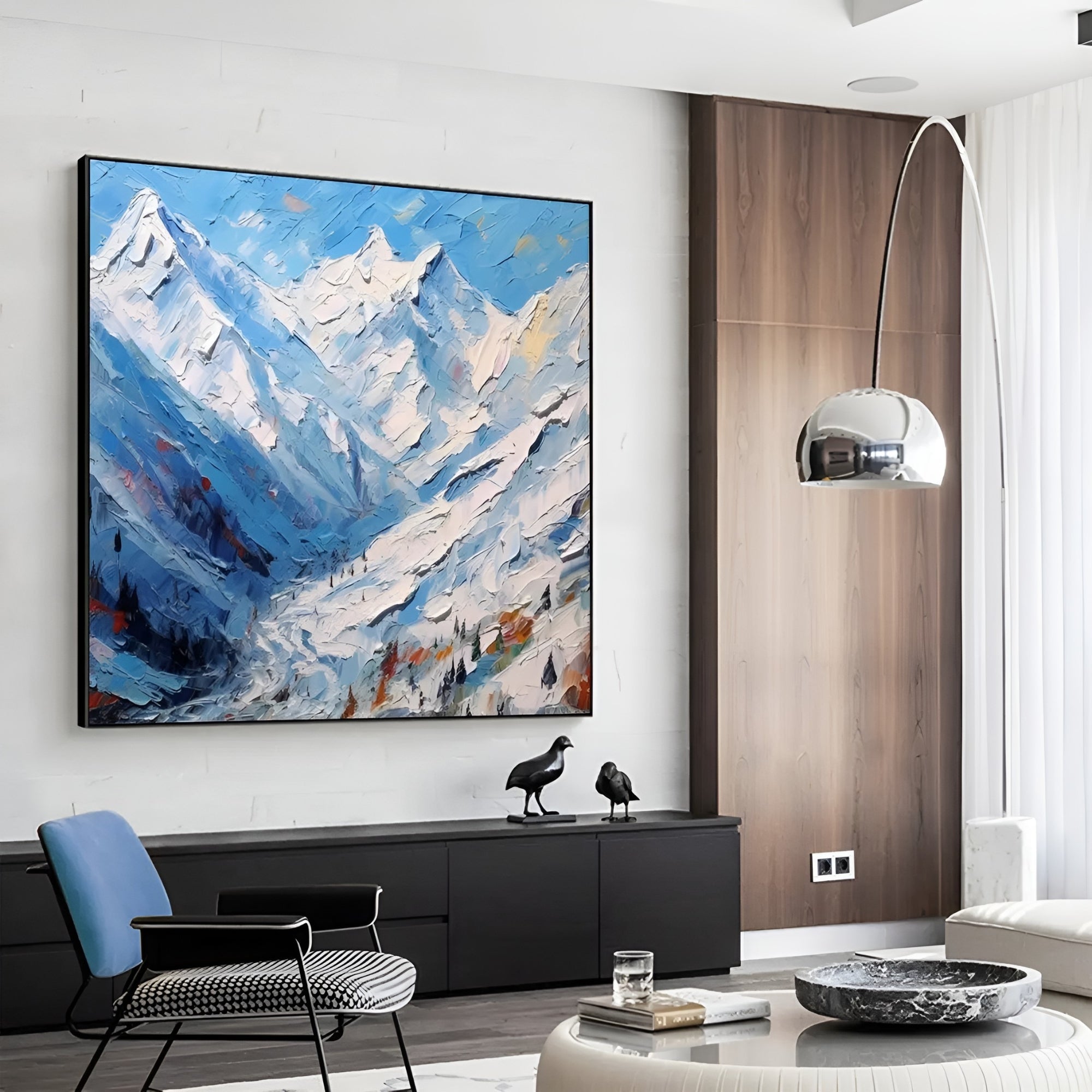 Winter mountain landscape wall art above an elegant green velvet couch.